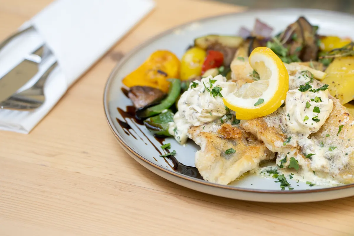 Pan-fried fish fillet with herb cream sauce and roasted vegetables at Restaurant Schachenwald